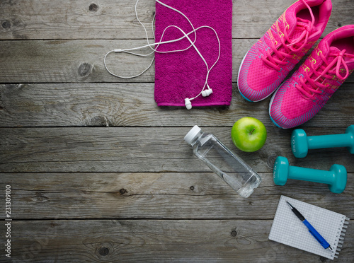  sneakers dumbbells bottle of water apple and audio headphones