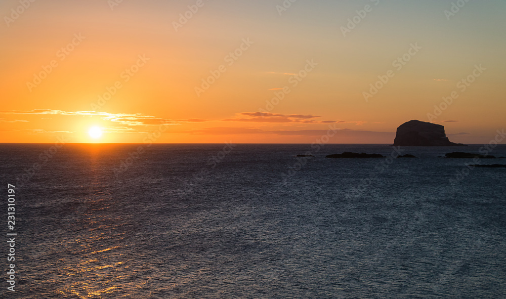 North see and Island Bass Rock at sunset. Thousands of gannets fly over the sea in search of food. North Berwick. Scotland North see and Island Bass Rock at sunset. Thousands of gannets fly over the sea in search of food. North Berwick. Scotland