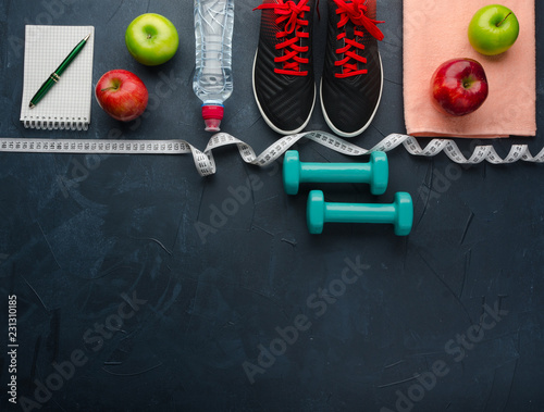 sneakers dumbbells bottle of water apple and measure tape