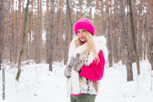 Fashion and people concept - Lovely young woman in warm jacket in winter park © satura_