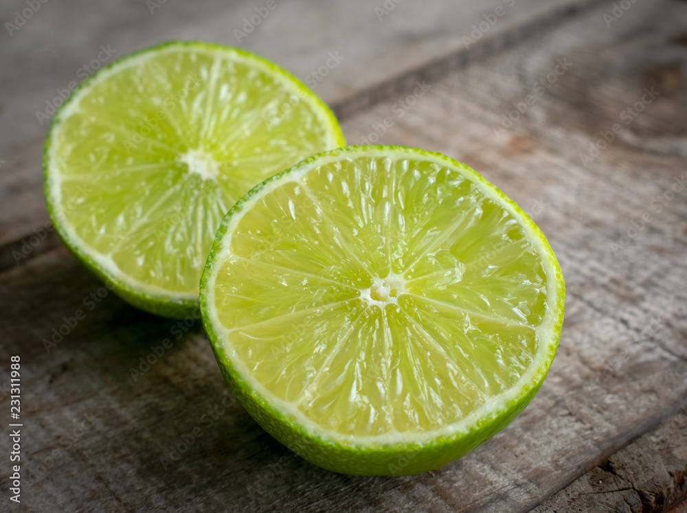 Lime cut in half on wood surface Lime cut in half on wood surface