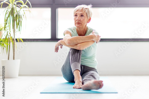Senior beautivul woman practise joga in room