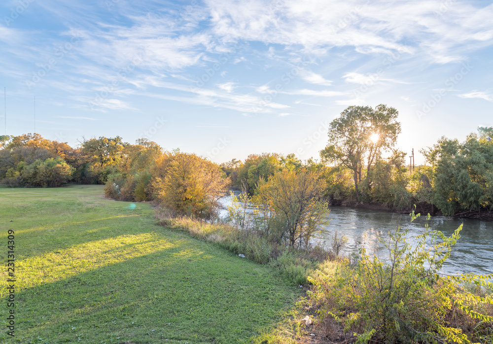 Φωτογραφία Beautiful riverside park with fall foliage vibrant color and sun peeking through trees in Carrollton, Texas, USA