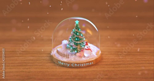 A loop animation of a Christmas crystal ball spinning on a wooden table.3d rendering.