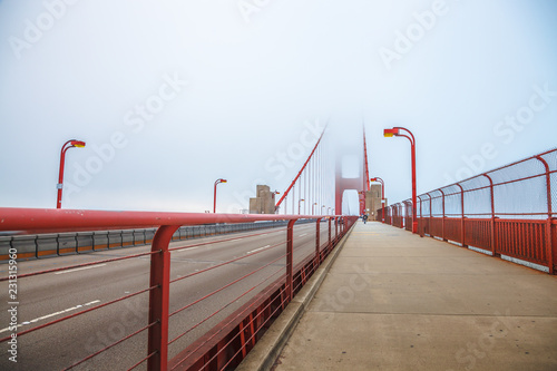 Perspective view of Golden Gate pedestrian path crossing Golden Gate Bridge from Presidio Pacific point to the north. In the fog of San Francisco Californian summer in United States of America. © bennymarty