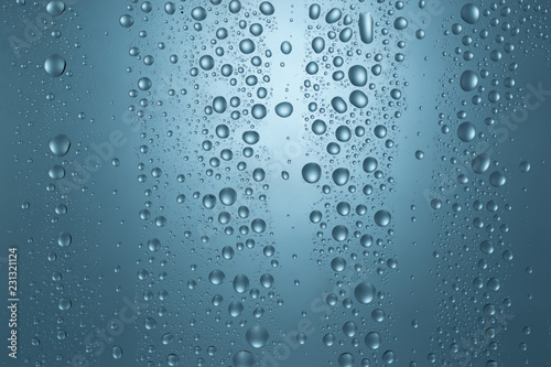 Water drops on round blue background, soft focus, close up © Cosminxp