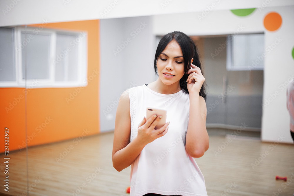 Concept of sport and healthy lifestyle. Fitness woman listening to music with earphones Concept of sport and healthy lifestyle. Fitness woman listening to music with earphones