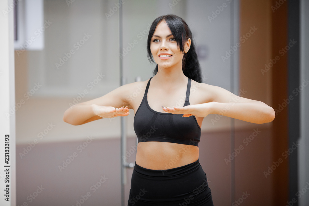 Concept of sport and healthy lifestyle. Cute brunette working out at a gym