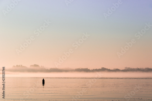 Cuadro en lienzo Water landscape with buoy at dawn