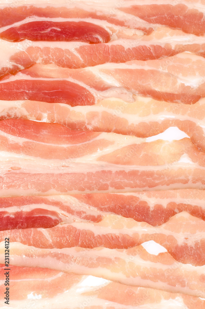 The background of thin strips of smoked bacon lie tightly together. The background of thin strips of smoked bacon lie tightly together.