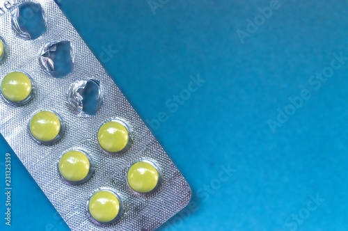 Yellow pills in the Pack launched on a blue background photo