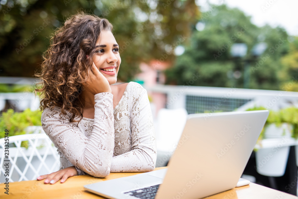 Portrait of an latin american young woman sitting at cafe with laptop writing her blog Portrait of an latin american young woman sitting at cafe with laptop writing her blog