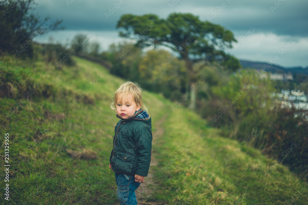 Little toddler walking on hillside in autumn Little toddler walking on hillside in autumn
