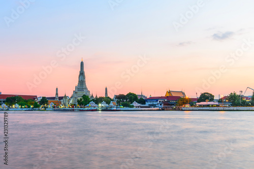Landmark Wat Arun Ratchawararam Ratchawaramahawihan with reflections on the river in sunset time