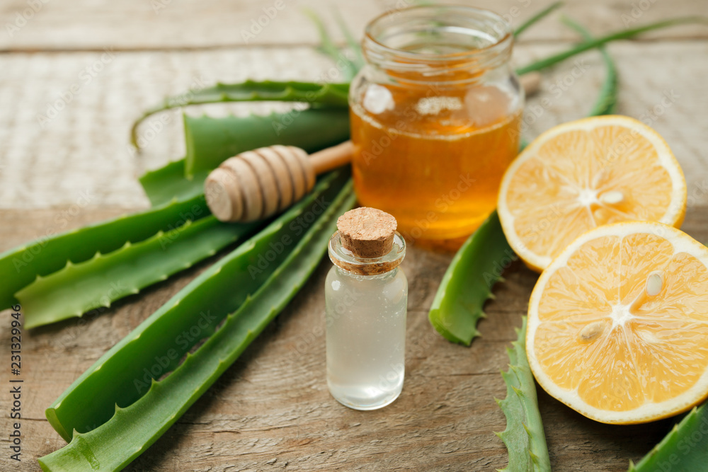 Honey, lemon, aloe vera leaves and essential oil for homeopathy remedy, alternative medicine closeup Honey, lemon, aloe vera leaves and essential oil for homeopathy remedy, alternative medicine closeup