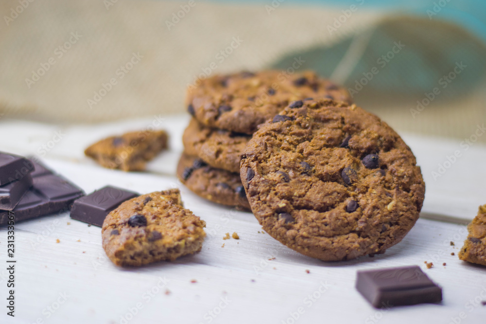 Oatmeal cookies with chocolate chips and chocolate lie on a light table. Oatmeal cookies with chocolate chips and chocolate lie on a light table.