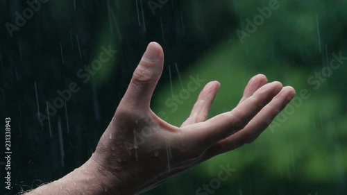 Slow motion 180fps closeup: Man uncurls fist into open palm in pouring rain
