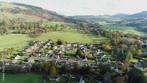 Aerial footage over the rural village of Fintry with views to the Campsie Fells. Flying away. photo