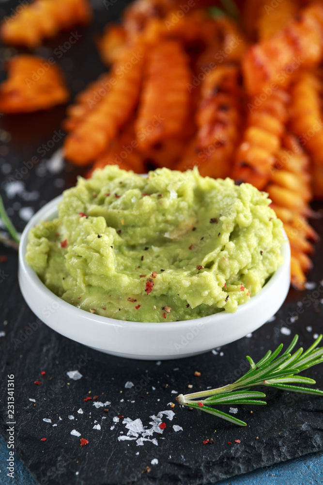 Baked butternut squash fries with sea salt, rosemary in paper cone. Pumpkin chips and quacamole dip Baked butternut squash fries with sea salt, rosemary in paper cone. Pumpkin chips and quacamole dip