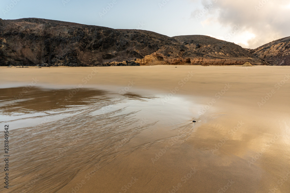 Sunrise landscape of a virgin golden sand beach in Lanzarote, Canary Islands.
