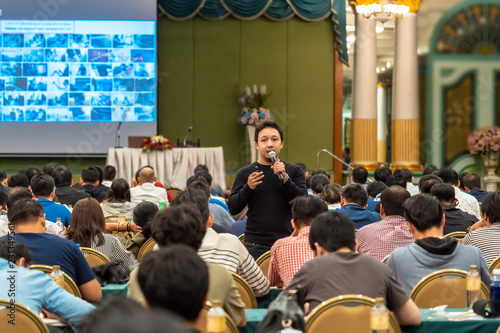 Asian Speaker with casual suit standing and giving the knowledge with audience in the conference hall or seminar meeting, business and education concept