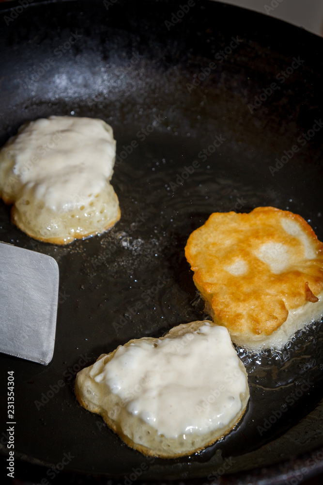 Cooking pancakes on a black pan with oil Cooking pancakes on a black pan with oil