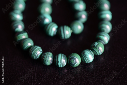 Malachite stone beads necklace on a dark background close up