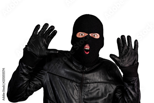 Arrested masked thief with raised arms isolated on white background