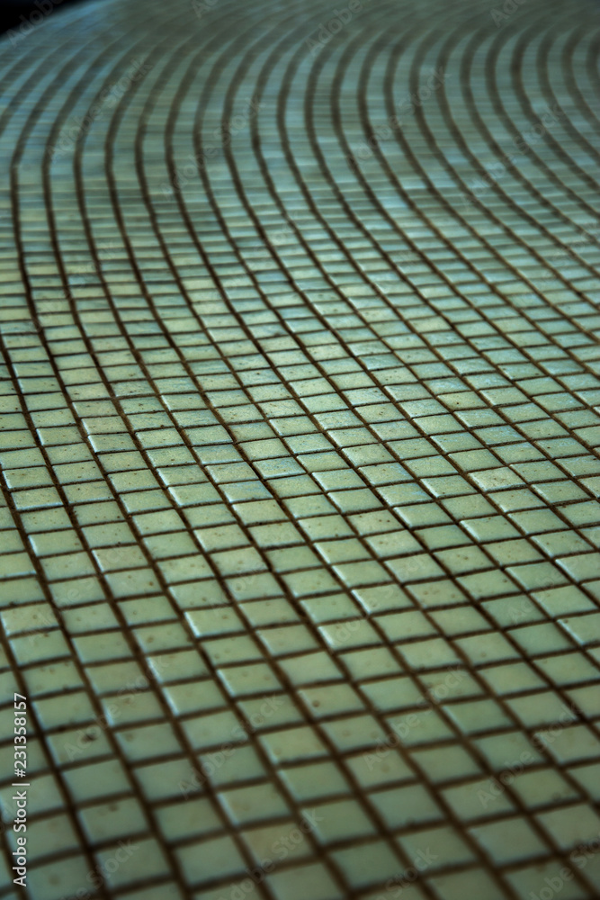 Wall background with an old ruined ceramic Venetian mosaic. Background of a white old ceramic mosaic as background for applying any design drawing. Cracked old dirty White Venetian mosaic on the wall