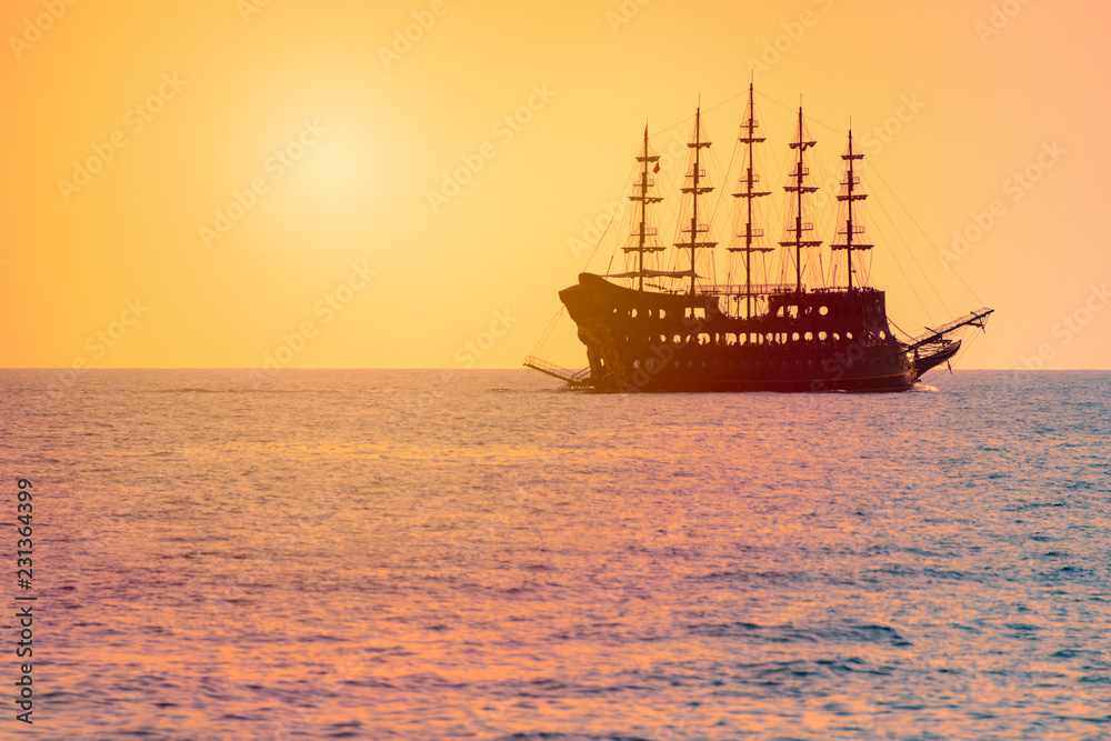 Cruise sailboat at sea at sunset on horizon