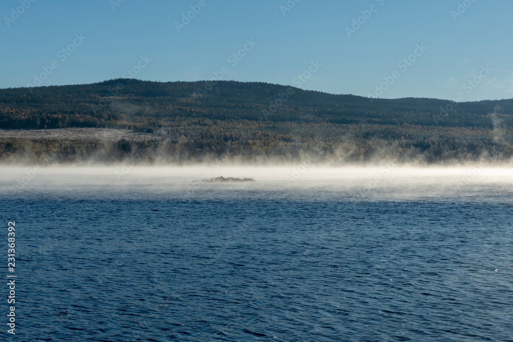 Morning fog leaving water surface in the morning sun Morning fog leaving water surface in the morning sun