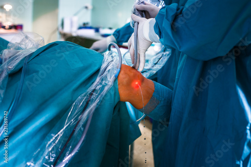 Knee surgery, Orthopedic Operation  -surgeons performing a knee surgery on a patient (shallow DOF; color toned image) photo