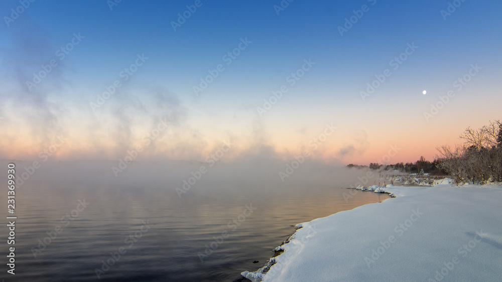 зимний пейзаж на Уральском озере с туманом и снегом на берегу, Россия, январь