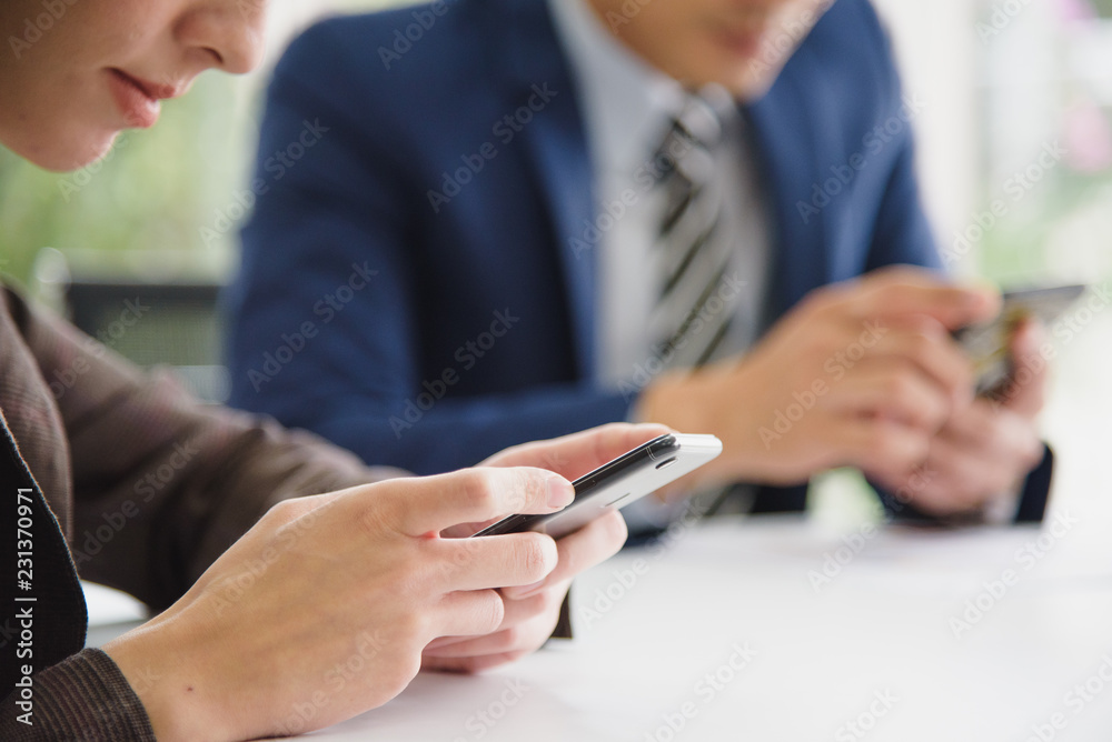 Close up of a business people, worker using mobile smart phone which sitting in the meeting room at office Close up of a business people, worker using mobile smart phone which sitting in the meeting room at office