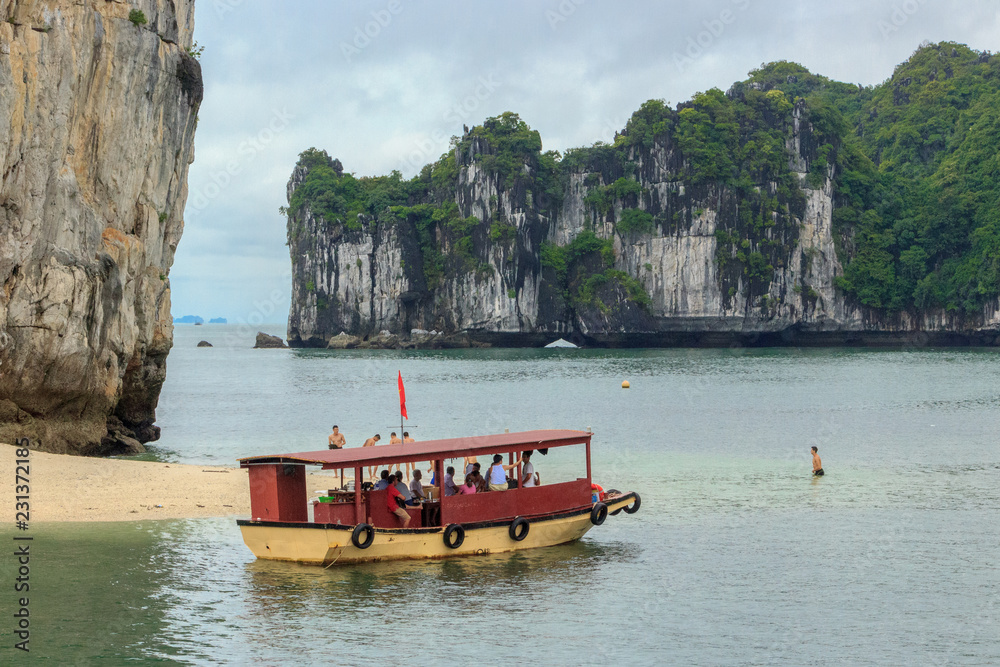 Naklejka premium boat at an island in ha long bay, vietnam