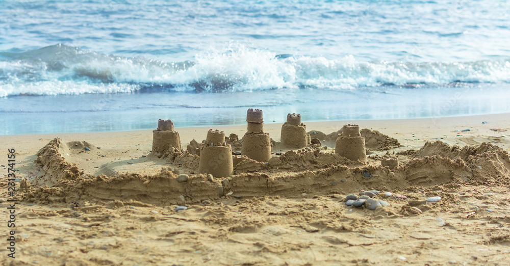 Sand castle on the beach near the surf line