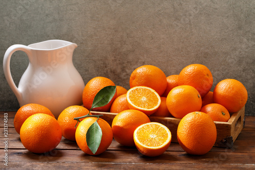 Φωτογραφία fresh orange fruits  in a box on wooden table