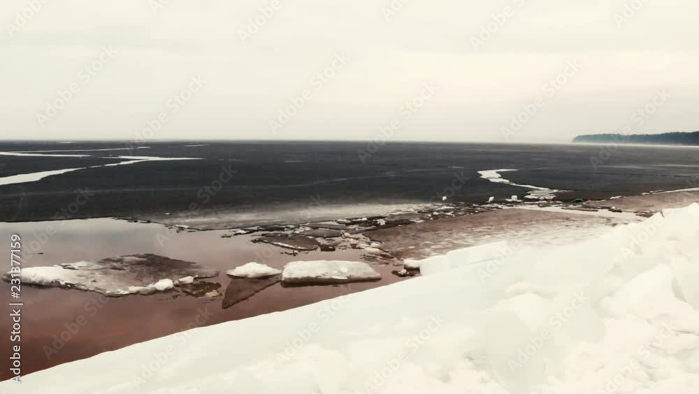 Sea coast line in spring during ice breaking. Slow pan of shore, frozen beach, ice and open water. Sea coast line in spring during ice breaking. Slow pan of shore, frozen beach, ice and open water.