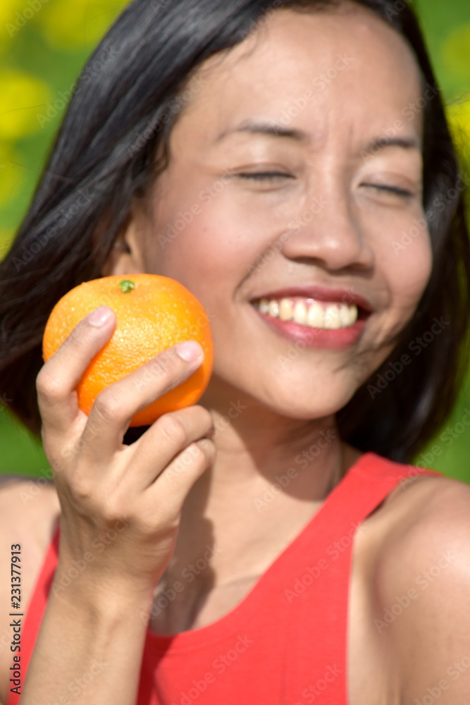 Smiling Youthful Diverse Female With An Orange Smiling Youthful Diverse Female With An Orange
