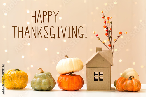Thanksgiving message with collection of autumn pumpkins with a toy house