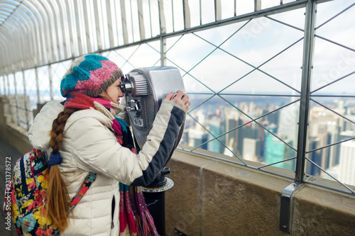 Canvas-taulu Happy young woman tourist at the observation deck of Empire State Building in New York City