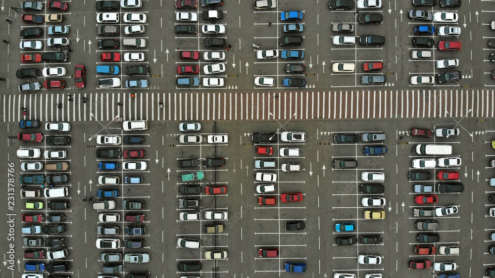 Aerial. Parking lots with a lot of cars and pedestrian crosswalk between them. Bird eye view above.