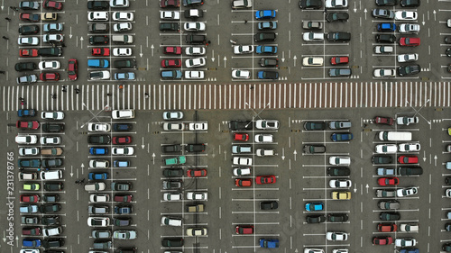 Aerial. Parking lots with a lot of cars and pedestrian crosswalk between them. Bird eye view above.