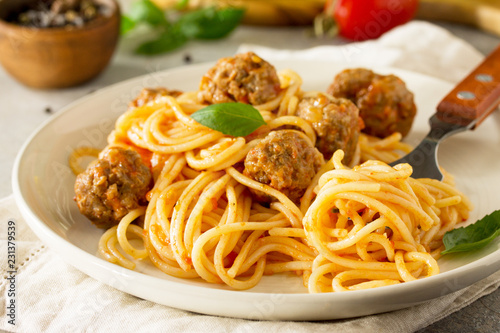 Italian style pasta dinner close-up. Spaghetti with Meatballs with Tomato Sauce on stone or concrete table.