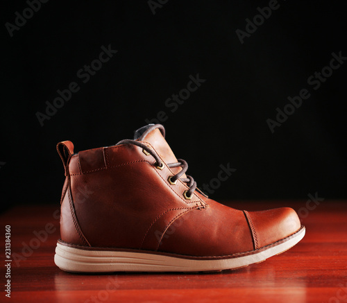 winter brown leather boots on a dark background. Modern fashion and style.