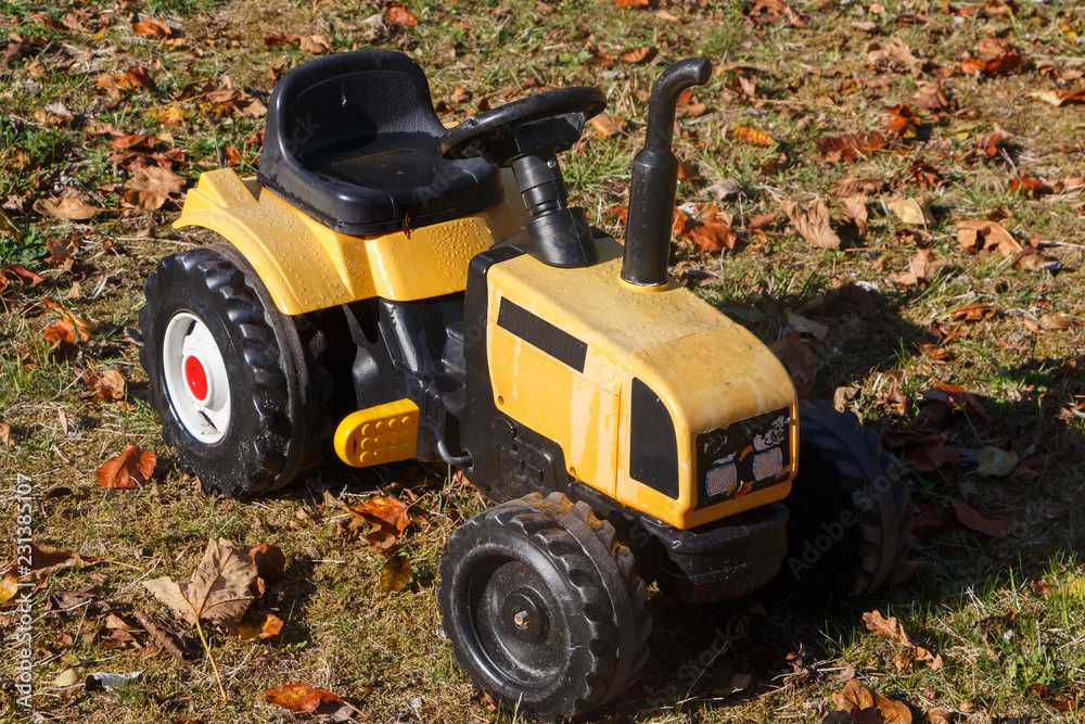 Obraz premium Tracteur à pédales pour enfant dans un jardin