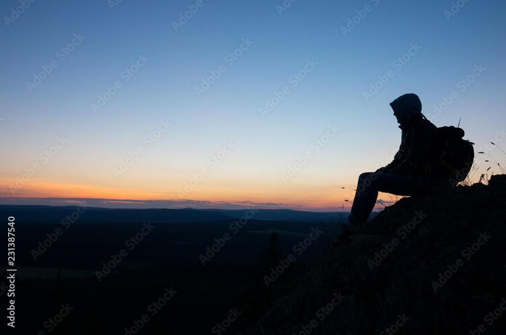 Man meets sunset on the top of the mountain.