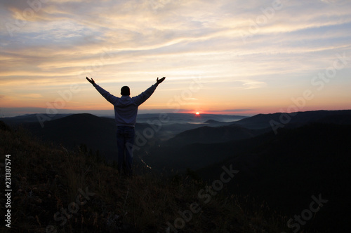 Man meets dawn on the top of the mountain.