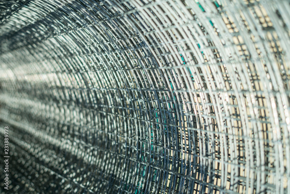 Fototapeta premium metal mesh twisted into a roll, close-up, as a background and abstraction