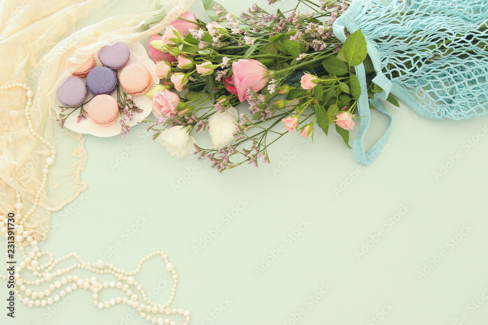 plate of macaroons over wooden table and flowers. plate of macaroons over wooden table and flowers.